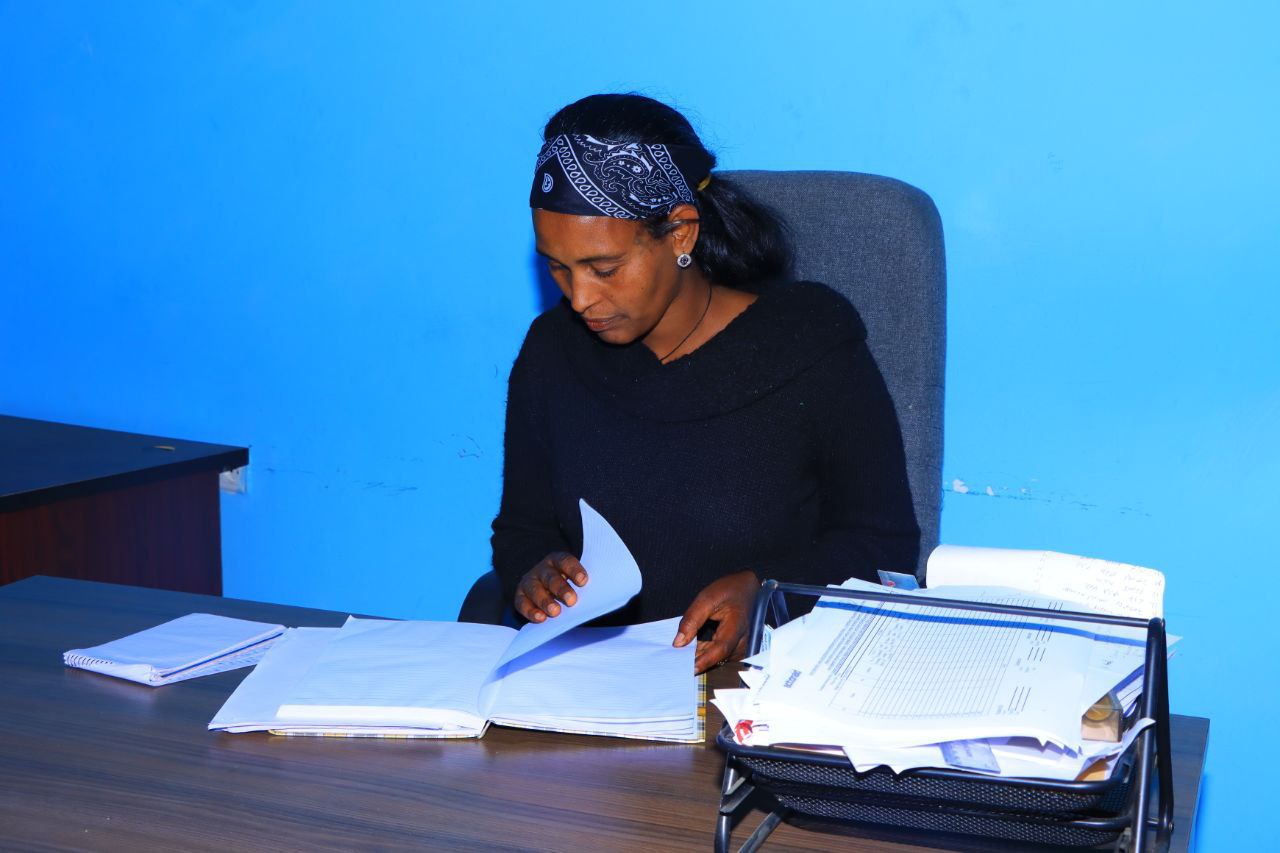 A picture of Abebu sitting at a desk