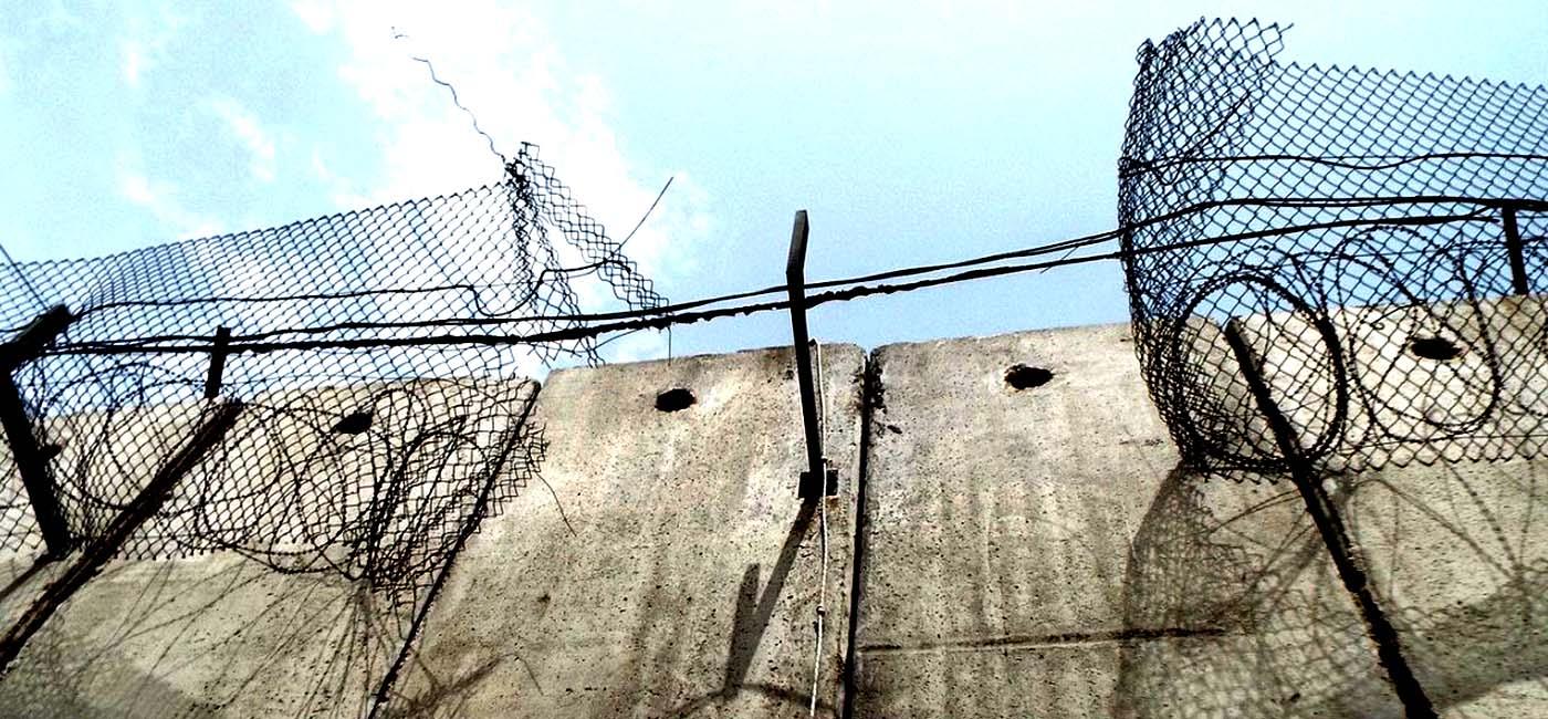 Concrete wall with fences and barbed wire